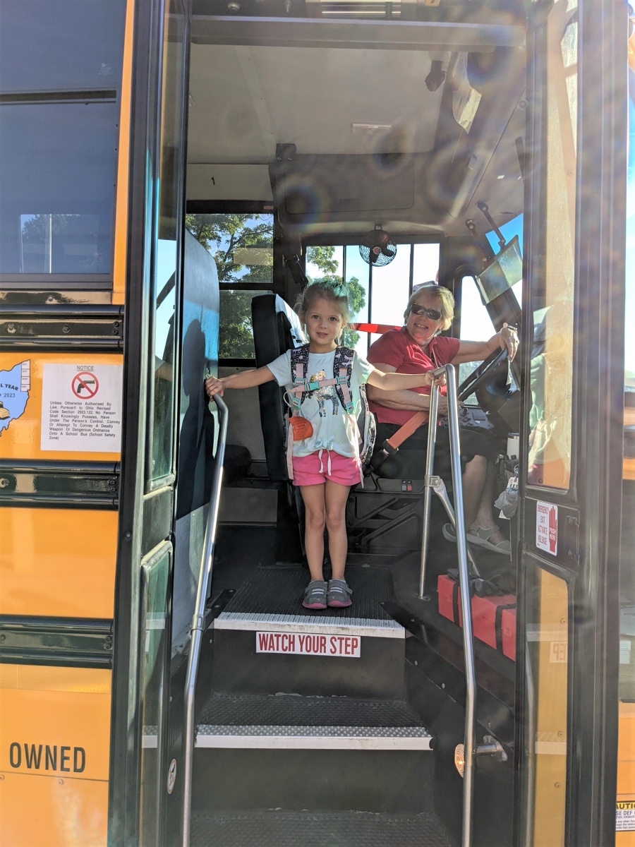 little girl getting off bus